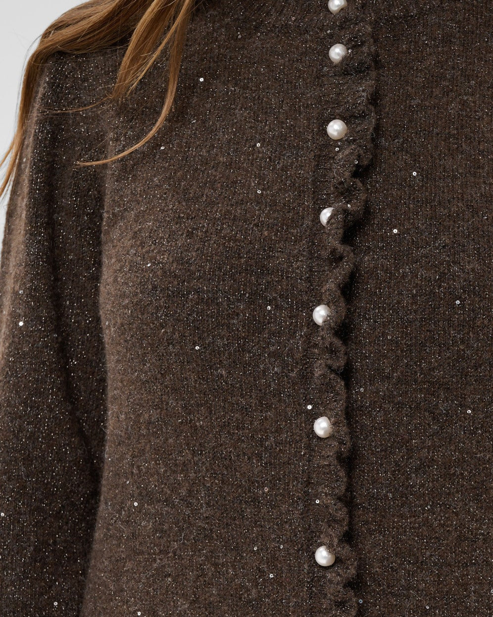 Nærbilde av perleknapper og paljetter på brun Cream cardigan